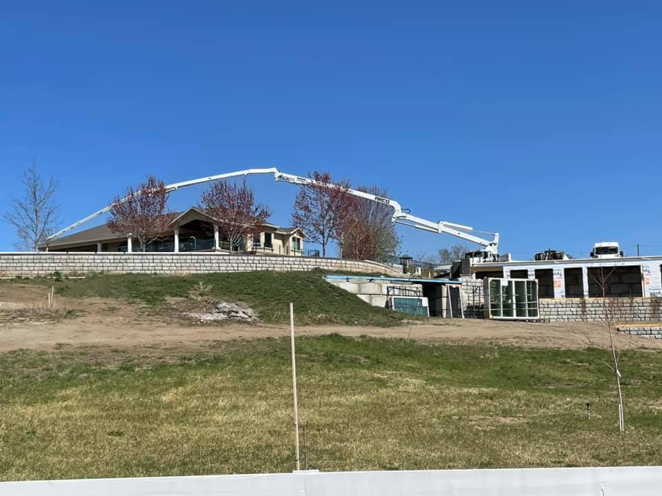 Arco Concrete Service | Arco concrete pump arm reaching into backyard in Kelowna